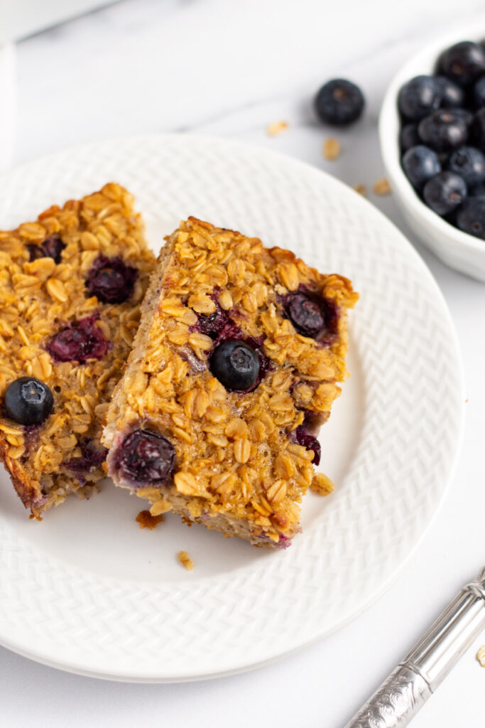 This blueberry baked oatmeal is an easy breakfast or snack recipe to prepare ahead of time. It’s a breakfast that can be eaten on the go, or served in the morning for the whole family. This baked blueberry oatmeal is also vegetarian and gluten-free. Use fresh or frozen blueberries, or swap in fruit already in the fridge! #bakedoatmeal #breakfastrecipes #easybreakfast #breakfastmealprep #blueberryrecipes