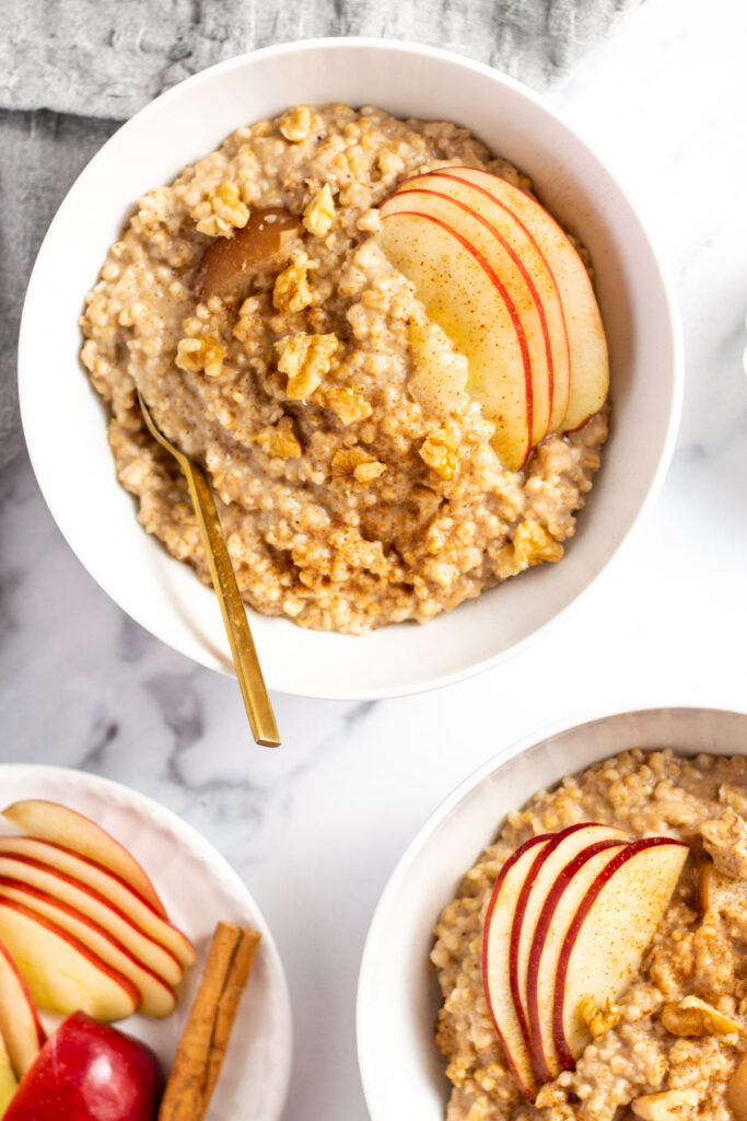 This amazingly simple apple spiced slow cooker oatmeal recipe is perfect for your breakfast meal prep. It only requires a few simple ingredients, a crock pot, very little prep or hands on time, and it's vegan, gluten free and dairy free! Made with applesauce and diced apples, this steel cut oatmeal is great for the fall but can always be enjoyed year round! #steelcutoats #slowcookeroatmeal #slowcookerrecipes #crockpot #appleoatmeal #glutenfree #dairyfree