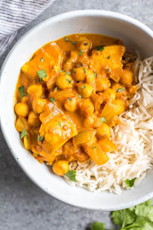 This easy slow cooker chicken and chickpea tikka masala is so simple to throw into your crock pot, and it's a lightened up, dairy-free and gluten-free version. Made with chickpeas (garbanzo beans), juicy chicken and a flavorful sauce, this recipe is perfect for a healthy weeknight meal or meal prep lunches. #slowcooker #dairyfreerecipes #glutenfreeslowcooker #chickenslowcookerrecipes