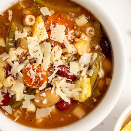 This slow cooker vegetarian minestrone soup is the epitome of healthy and hearty. It's great as an easy meatless meal, or served along side of chicken or beef as a side. The crock pot does all of the work for you, and the end result is a flavorful Italian style soup that's vegan, dairy-free, and loaded with beans, pasta (with a gluten-free option), and vegetables like celery, carrots, potatoes, green beans and tomatoes. #veganminestrone #vegansoup #slowcookersoup #vegetarianslowcooker #crockpotminestrone