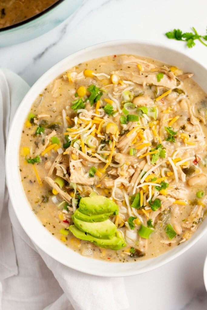 This gluten- free white bean turkey chili is the perfect way to use up leftover turkey, and a simple recipe to make a healthy weeknight dinner. It cooks on the stovetop in one pot in 30 minutes, and reheats well if you're making it for meal prep. There's very little prep work involved, so everything comes together quickly! #glutenfree #whitebeanchili #turkeyrecipes #leftoverturkey #turkeychili