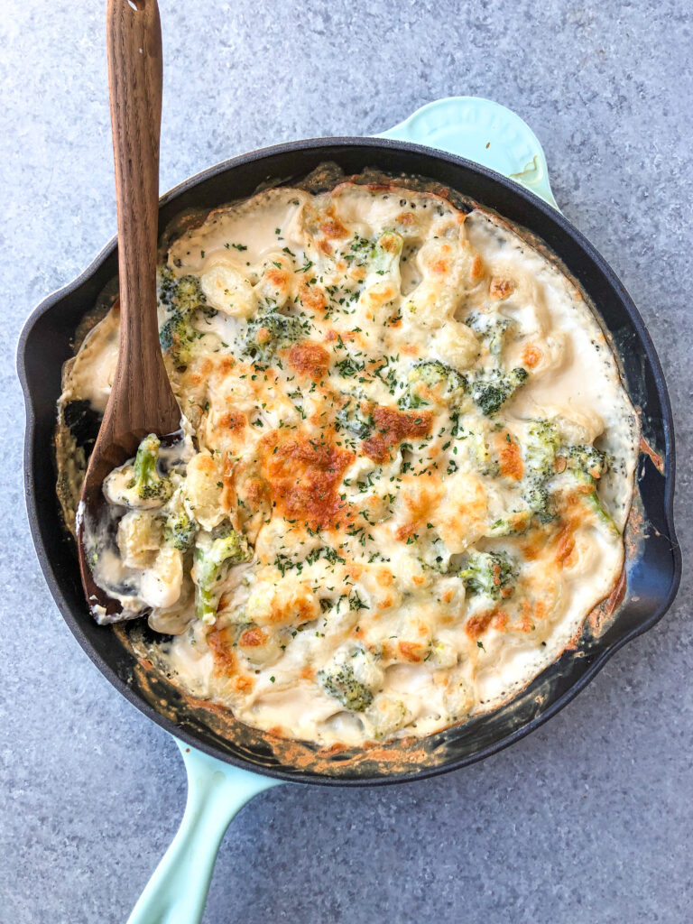 This cheesy broccoli gnocchi skillet is a super easy meatless recipe that can be made vegetarian and gluten-free. The pillowy gnocchi skillet, made in under 30 minutes, is a satisfying dish that will have even the kids eating their broccoli and wanting more. #meatlessrecipes #gnocchiskillet #broccolignocchi #meatlessdinner