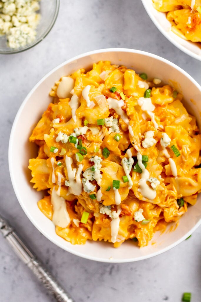 This instant pot buffalo chicken pasta is an easy one dish meal that can be made gluten-free. It comes together in 30 minutes, requires very little hands-on time, and is perfectly zesty and creamy. This instant pot pasta recipe also has plenty of veggies like onions, celery and tomatoes. It's a delicious easy weeknight dinner or meal prep recipe everyone is sure to love! #instantpotpasta #buffalochickenpasta #instantpotchicken #chickenpasta #glutenfreepasta
