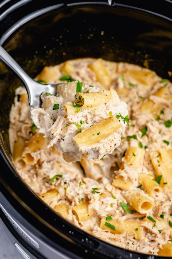 Slow cooker chicken Alfredo pasta is a satisfying meal any day of the week. Made even better with an easy homemade Alfredo sauce! It's easy to make gluten free or vegetarian, and made with only a few simple ingredients you likely have at home already. Let your crock pot do the work and add this chicken alfredo pasta to your weeknight meal rotation! #chickenalfredo #alfredopasta #slowcookerpasta #homemadealfredo
