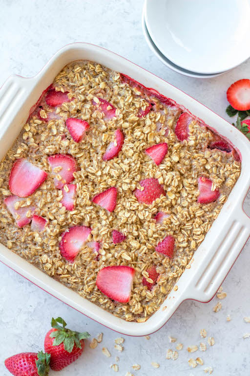 This easy and healthy strawberry baked oatmeal recipe is made with rolled oats, dairy free milk, and the perfect combination of maple syrup and cinnamon! It's totally gluten free, makes great breakfast meal prep, cooks in just 30 minutes, and can be assembled the night before to be baked the next day! #glutenfreebreakfast #breakfastmealprep #dairyfree #strawberryoatmeal #bakedoatmeal