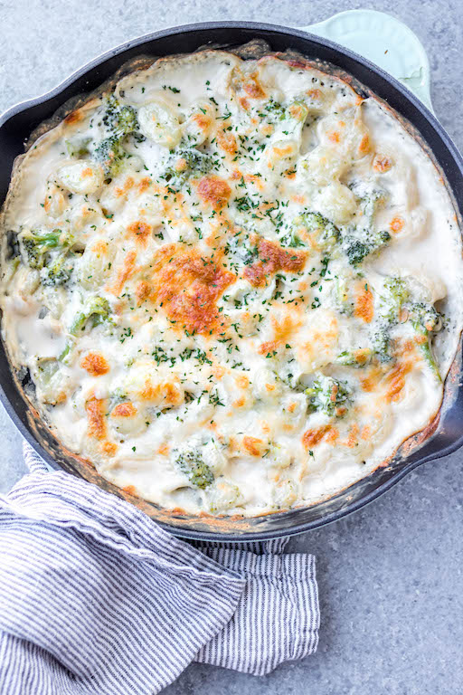 This cheesy broccoli gnocchi skillet is a super easy meatless recipe that can be made vegetarian and gluten-free. The pillowy gnocchi skillet, made in under 30 minutes, is a satisfying dish that will have even the kids eating their broccoli and wanting more. #meatlessrecipes #gnocchiskillet #broccolignocchi #meatlessdinner