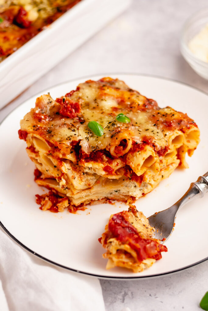 This easy meatless baked ziti is made with 3 cheeses layered in one delicious pasta dish. The ricotta, mozzarella, and parmesan melt together with the red sauce and ziti noodles for a satisfying vegetarian dinner that can easily be made gluten free. Baked in the oven in a quick 35 minutes, with only a few ingredients you likely already have in the pantry; you can't go wrong! #easymeatlessbakedziti #3cheesebakedziti #glutenfreebakedziti